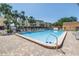 A clean, inviting community pool surrounded by lounge chairs and tropical palm trees at 472 Sandy Hook Rd, Treasure Island, FL 33706