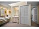 Bright bathroom features vanity with Hollywood-style mirror and lighting, spacious closet, and skylight above at 508 N Mayo St, Crystal Beach, FL 34681