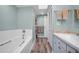 Well-lit bathroom featuring a bathtub with shower, vanity, built-in storage, and skylight, designed for convenience and comfort at 508 N Mayo St, Crystal Beach, FL 34681