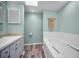 Inviting bathroom with a tub and shower, vanity with neutral countertop, and skylight, creating a relaxing atmosphere at 508 N Mayo St, Crystal Beach, FL 34681