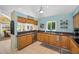 Kitchen with wooden cabinets, dark countertops, stainless steel appliances, and a view to the dining area at 508 N Mayo St, Crystal Beach, FL 34681