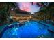 Backyard pool with a sun deck, solar panels, manicured lawn, and outdoor seating at 508 N Mayo St, Crystal Beach, FL 34681