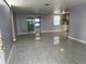 Open-concept living room with tile flooring and sliding glass doors at 5151 Janice Ln, Holiday, FL 34690
