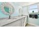 Modern bathroom with double sinks, white cabinets, and decorative mirrors at 5200 Brittany S Dr # 1502, St Petersburg, FL 33715