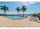 Relax by the community pool on a sunny day with palm trees and ocean views at 5200 Brittany S Dr # 1502, St Petersburg, FL 33715