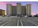 A large apartment building with multiple floors stands above a parking lot filled with parked cars at 5200 Brittany S Dr # 1502, St Petersburg, FL 33715
