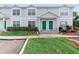 Inviting townhome showcasing a well-manicured lawn and vibrant green door, creating a warm curb appeal at 5503 67Th N Ave # 18, Pinellas Park, FL 33781