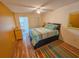 Cozy bedroom with a ceiling fan, wood floors, and access to a sunroom at 5935 30Th S Ave # 308, Gulfport, FL 33707