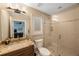 A well-lit bathroom with tile, a glass enclosed shower, and a granite vanity at 597 Bay St, Palm Harbor, FL 34683