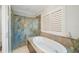 Relaxing bathroom with a standalone tub and a glass-enclosed shower with decorative tile at 597 Bay St, Palm Harbor, FL 34683
