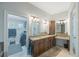 Bathroom featuring a double vanity, granite counters, and access to a walk-in closet at 597 Bay St, Palm Harbor, FL 34683