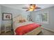 A well lit bedroom featuring an ornate ceiling fan, bright shuttered windows, and neutral decor at 597 Bay St, Palm Harbor, FL 34683