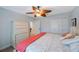 A nicely decorated bedroom features white furniture, neutral walls, and a unique ceiling fan at 597 Bay St, Palm Harbor, FL 34683