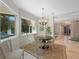 Cozy dining room features natural light, wood table, chandelier, and views of backyard at 597 Bay St, Palm Harbor, FL 34683