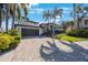 Beautifully landscaped home featuring a two-car garage and a lovely front yard with tropical trees at 597 Bay St, Palm Harbor, FL 34683