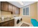 Functional laundry room with washer, dryer, sink, and wood cabinets at 597 Bay St, Palm Harbor, FL 34683