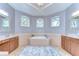 Bright bathroom with dual vanities, large soaking tub, three windows, and neutral color scheme at 6112 Ibispark Dr, Lithia, FL 33547
