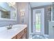 Bathroom featuring single sink vanity with white countertop and a door leading to the yard at 6112 Ibispark Dr, Lithia, FL 33547