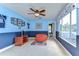 Bright blue bedroom with large windows, ceiling fan, comfortable carpet, and football decor at 6112 Ibispark Dr, Lithia, FL 33547