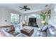 Comfortable living room with a large leather sectional, hardwood floors, ceiling fan, and access to the outdoor patio at 6112 Ibispark Dr, Lithia, FL 33547