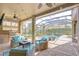 Covered lanai with outdoor kitchen, fireplace and seating area overlooking the screened-in pool at 6112 Ibispark Dr, Lithia, FL 33547
