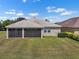 Back exterior featuring a screened lanai and a spacious lawn at 626 15Th Nw Ave, Ruskin, FL 33570