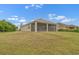 Back exterior featuring a covered lanai and well-maintained lawn at 626 15Th Nw Ave, Ruskin, FL 33570