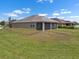 Back exterior showing a screened-in lanai and a large green lawn at 626 15Th Nw Ave, Ruskin, FL 33570