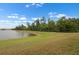 Lakeside backyard with lush green lawn and trees at 626 15Th Nw Ave, Ruskin, FL 33570