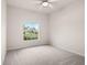 Neutral bedroom with a large window providing natural light and a view of the neighborhood, ceiling fan, carpet floors at 626 15Th Nw Ave, Ruskin, FL 33570