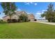 Lovely one-story home with a manicured lawn, mature landscaping, and a glimpse of the lake in the background at 626 15Th Nw Ave, Ruskin, FL 33570