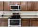 Modern kitchen boasts stainless steel oven, microwave, cooktop and stylish dark wood cabinets at 626 15Th Nw Ave, Ruskin, FL 33570