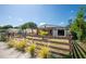 Inviting home featuring a well-maintained lawn, complemented by a charming wooden fence and lush greenery at 630 48Th N Ave, St Petersburg, FL 33703
