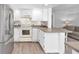 Bright kitchen featuring white cabinets, laminate floors and breakfast bar at 630 48Th N Ave, St Petersburg, FL 33703