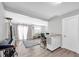 Open concept living room with gray wood flooring, white walls, and a sewing machine at 630 48Th N Ave, St Petersburg, FL 33703