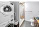 Modern bathroom featuring a stacked washer/dryer and tiled shower at 6515 Dimarco Rd, Tampa, FL 33634