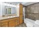 Well-lit bathroom with ceramic tile flooring, framed mirror, and a shower-tub combo at 6515 Dimarco Rd, Tampa, FL 33634