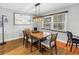 Dining area with hardwood floors, a wooden table with seating for six, and a modern light fixture at 6515 Dimarco Rd, Tampa, FL 33634