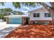 Charming two-story home boasts colorful garage door, brick accents, and lush landscaping at 6515 Dimarco Rd, Tampa, FL 33634