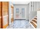 Inviting foyer with decorative glass doors, unique tile flooring, and a conveniently located coat closet at 6515 Dimarco Rd, Tampa, FL 33634