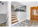 Welcoming foyer featuring tiled floors, stairs to the second floor, and a wooden front door at 6515 Dimarco Rd, Tampa, FL 33634