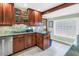 Stylish kitchen with wood cabinets, granite counters, stainless steel appliances, and a glass block window at 6515 Dimarco Rd, Tampa, FL 33634