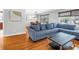 Comfortable living room with a large blue sofa, hardwood floors, and a view into the dining area at 6515 Dimarco Rd, Tampa, FL 33634