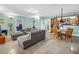 Comfortable open-concept living and dining area with tile floors and a large gray sectional couch at 6515 Dimarco Rd, Tampa, FL 33634