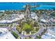 Aerial view of a coastal neighborhood with shopping district, lush green spaces, and stunning waterfront vistas at 6994 Country Lakes Cir, Sarasota, FL 34243