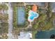 Aerial view of a tennis court and community pool surrounded by lush greenery at 6994 Country Lakes Cir, Sarasota, FL 34243