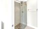Modern bathroom featuring a glass shower with elegant tile surround and pebble flooring at 6994 Country Lakes Cir, Sarasota, FL 34243