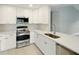 This is a kitchen with stainless steel appliances and white cabinets and counter tops at 6994 Country Lakes Cir, Sarasota, FL 34243