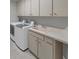 Convenient laundry room with modern washer and dryer, cabinets, and a sink at 6994 Country Lakes Cir, Sarasota, FL 34243