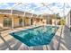 Inviting screened-in pool area with blue tiled pool and beautiful neutral colored deck at 6994 Country Lakes Cir, Sarasota, FL 34243